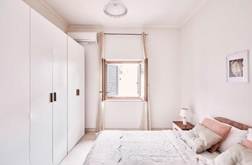 a white bedroom with a bed and a window at Casa del Principe in Ottaviano