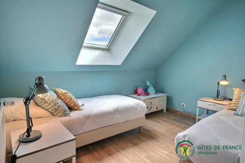 a bedroom with two beds and a window at La Lézardière in Pleugriffet