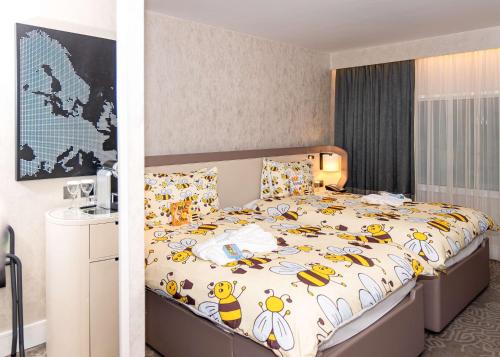 a bedroom with a large bed with a bunch of bees on it at Hilton London Heathrow Airport in Hillingdon