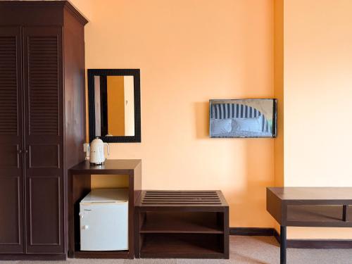 a room with a desk and a table and a mirror at The Très Hotel in Kuala Lumpur