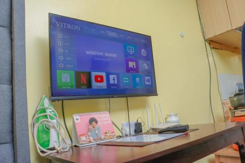 a flat screen tv hanging on a wall above a desk at Trendy Homes Studio BnB in Bungoma