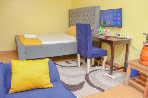 a bedroom with a bed and a desk with a computer at Trendy Homes Studio BnB in Bungoma