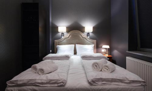 a bedroom with a bed with towels on it at Cocorico Bed and Breakfast OLD TOWN Szczecin Adults Only in Szczecin