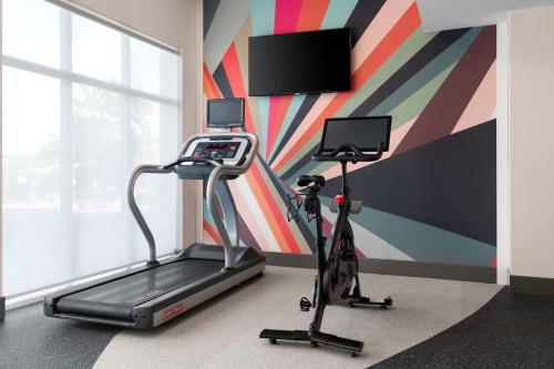 a gym with a treadmill and a tv on a wall at Hilton Garden Inn Kennett Square in Kennett Square