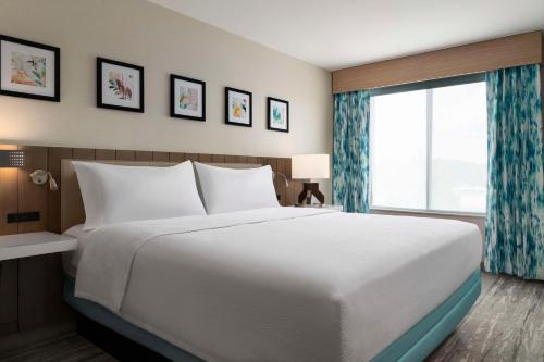 a bedroom with a large bed and a large window at Hilton Garden Inn Kennett Square in Kennett Square