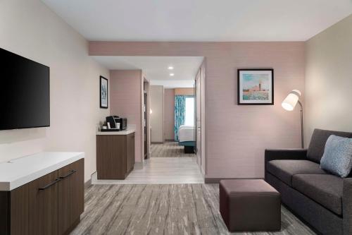a living room with a couch and a tv in a room at Hilton Garden Inn Kennett Square in Kennett Square