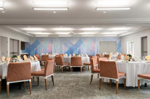 a dining room with tables and chairs and a room with at Hilton Garden Inn Kennett Square in Kennett Square