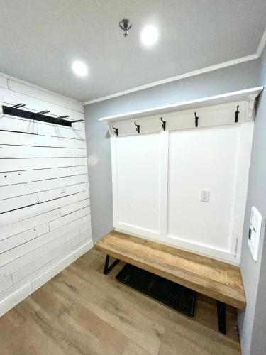 a room with a white closet with a wooden bench at Luxury Condo with Garage Parking and Pool in Killington
