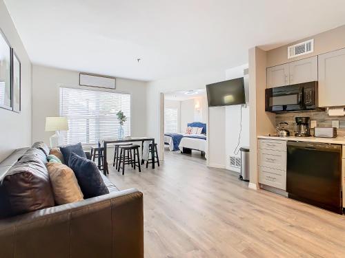 a living room and kitchen with a couch and a table at Be Our Guest! 1 Bedroom Condo Near Disney Parks! in Orlando