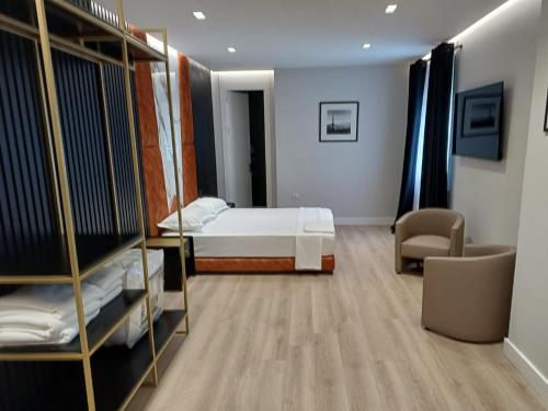 a bedroom with a bed and a room with a chair at Oxygen Boutique Hotel in Tirana