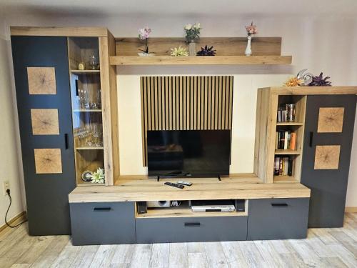 a large entertainment center with a flat screen tv at Ferienwohnung Blumen in Radeberg