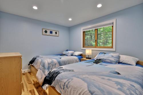 ein Schlafzimmer mit zwei Betten und einem Fenster in der Unterkunft Fun In Fun Out Ski Home - Upper Unit, Renovated 3BR-2BA, Hot Tub, Close to Resort in Killington