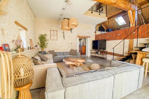 un grand salon avec un canapé et une table dans l'établissement Magnifique maison de campagne aux portes de Sancerre, by Rurals, à Gardefort
