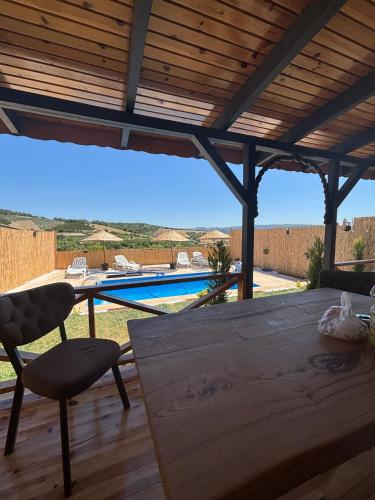 a patio with a table and a chair and a pool at Uysal Dağevleri in Bilecik
