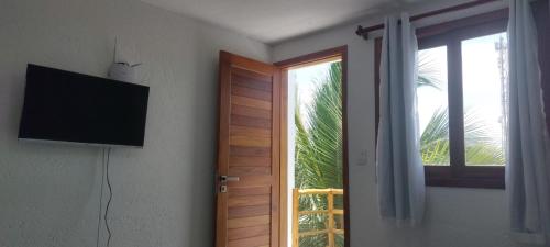 ジェリコアコアラにあるROOFTOP Suítes JERIのテレビ付きの部屋、窓付きのドア