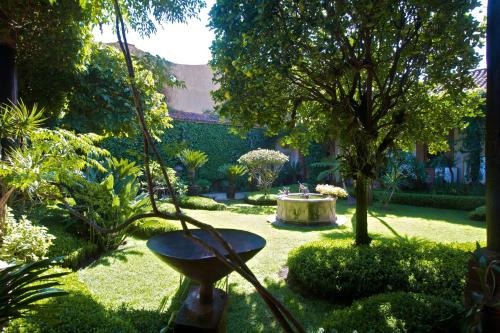 a garden with a swing in the yard at Casa de la Real Aduana Boutique Hotel in Pátzcuaro