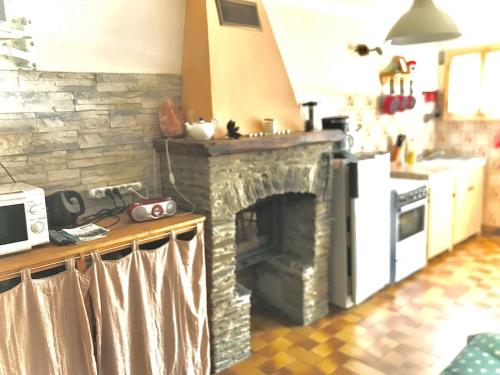 a kitchen with a stone fireplace in a kitchen at Charmant séjour au cœur des vignes de Banyuls in Banyuls-sur-Mer