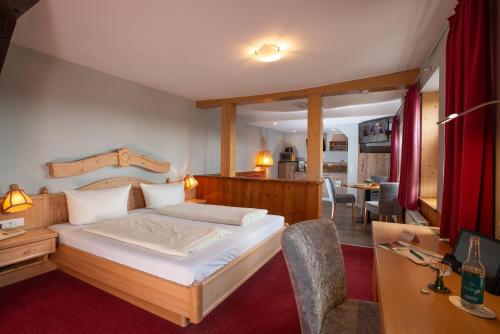 a bedroom with a bed and a dining room at Hotel und Restaurant zum Schiffchen in Wolfhagen