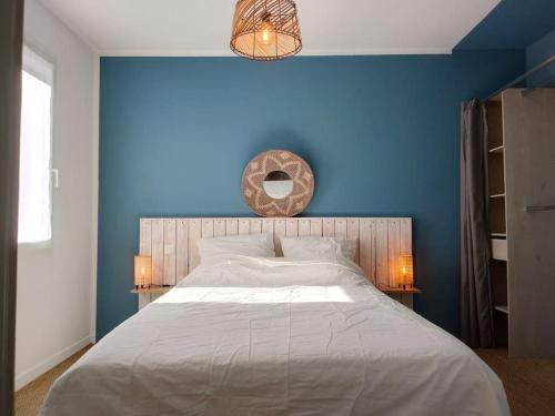 - une chambre avec un mur bleu et un grand lit dans l'établissement Maison Les Orangers, proche Uzès, à Garrigues-et-Sainte-Eulalie