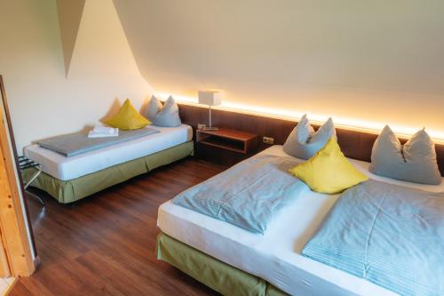 a hotel room with two beds with yellow pillows at Hotel Restaurant Taverna in Eching