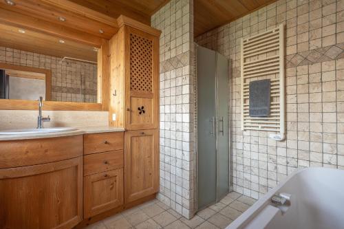 une salle de bain avec une baignoire, un lavabo et une douche dans l'établissement Chalet Mouflon des Neiges, aux Gets