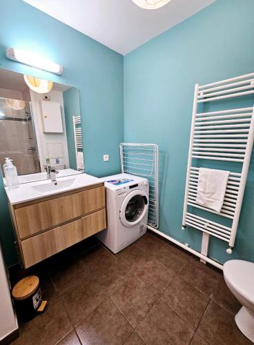 une salle de bain avec une machine à laver et un lavabo dans l'établissement Bel appartement avec parking privé, à Boussy-Saint-Antoine