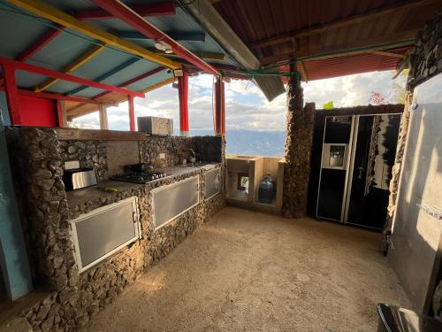 a kitchen with a stove and a stone wall at Cabaña Parque Arvi vista panorámica in Medellín