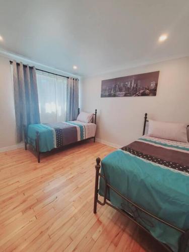 a bedroom with two beds and a large window at Le cosy for familys, home work in Longueuil