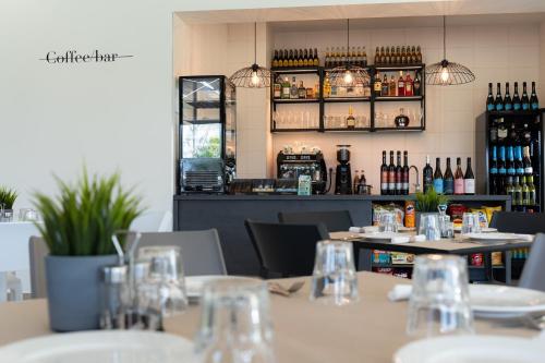 a restaurant with tables and chairs with wine bottles at Noa Panzio in Vecsés