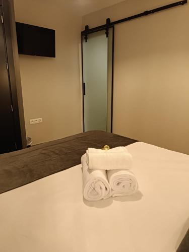 a pair of towels sitting on a bed in front of a mirror at Alma Urbana Alojamiento in Málaga