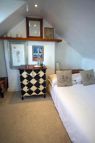 a attic room with two beds and a table with at Charming 3 bedroom house with indoor wood burner. in Frome