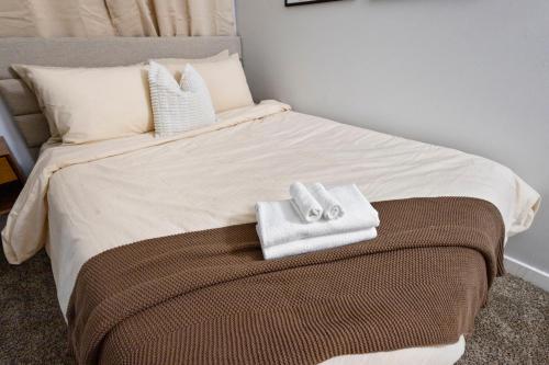 a bed with two towels sitting on top of it at Downtown Indy 2BR-Stadium, Convention - Arcade Games in Indianapolis