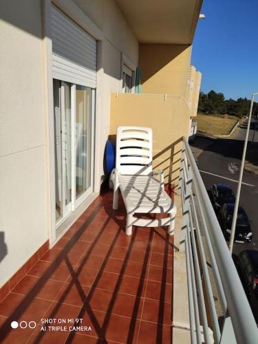 a chair sitting on the balcony of a house at Sweet Ericeira Surf, Apartment in Ericeira