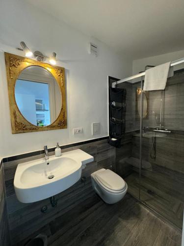 a bathroom with a sink and a toilet and a mirror at Regginè Holiday Apartments in Sant'Agnello
