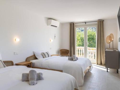 a hotel room with two beds and a balcony at Villa La Telaranya - Luxury villa with heated pool close to Port Pollença in Port de Pollensa