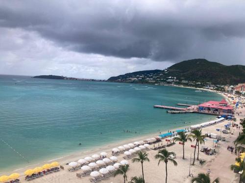 a beach with umbrellas and people on the water at Sand & Sea in Philipsburg