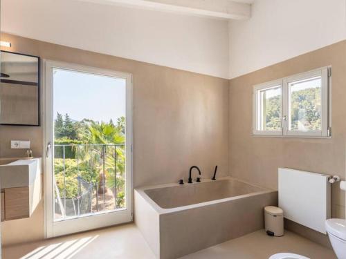 a bathroom with a large bath tub and a window at Villa La Telaranya - Luxury villa with heated pool close to Port Pollença in Port de Pollensa