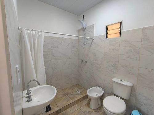 a white bathroom with a toilet and a sink at Departamentos Boiko in Leandro N. Alem