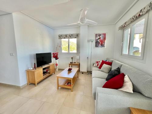 a living room with a couch and a tv at Stunning sunlight apartment with a pool view in Sucina
