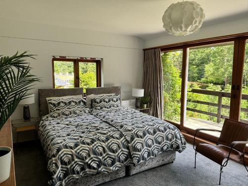 オックスフォードにあるSpacious and stylish with games room, huge garden, peaceful surroundingsのベッドと大きな窓のある寝室