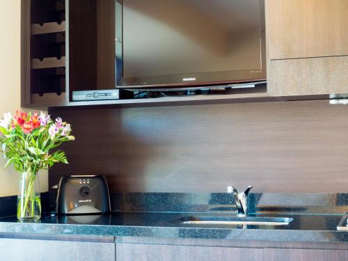 a kitchen with a sink with a tv above it at Two Independent Palermo Hollywood Studios at Buenos Aires's Best Neighborhood in Buenos Aires