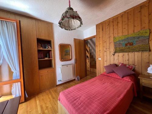 une chambre avec un lit avec une couverture rouge dans l'établissement Cottage Deluxe - nel cuore di Asiago, à Asiago