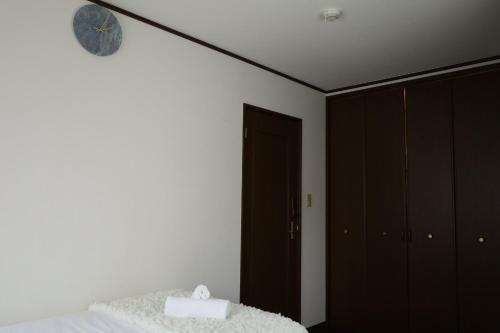 a bedroom with a bed and a clock on the wall at 西川口ハウス最大12名家族団体 in Toda