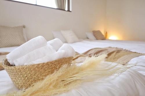 a basket of towels sitting on top of a bed at 西川口ハウス最大12名家族団体 in Toda