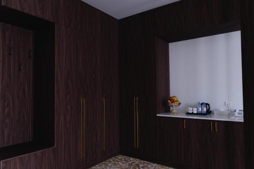 a room with dark wood cabinets and a window at Boutique Hotel Tomiris in Astana