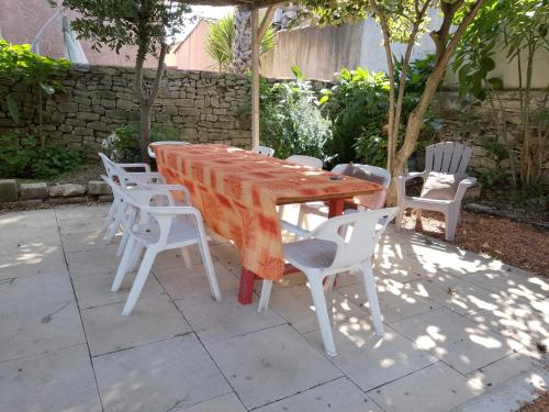 a table and chairs with an orange table and chairs at Chambre 2 personnes a Calvisson Gard in Calvisson