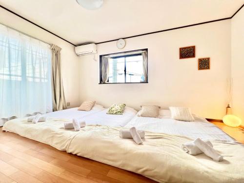 two large white beds in a room with a window at 西川口ハウス最大12名家族団体 in Toda