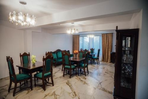 a dining room with a table and green chairs at Agropensiunea Casa Daiana Breb in Breb