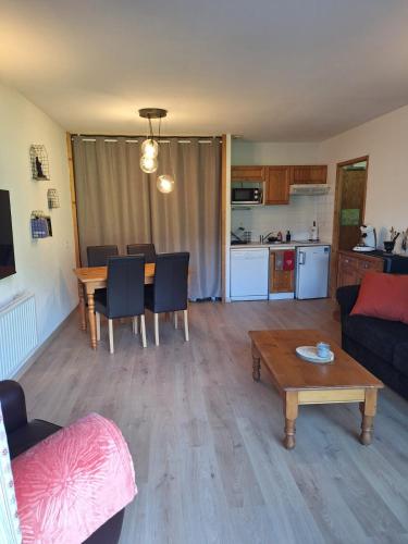 un salon avec un canapé et une table et une cuisine dans l'établissement Très bel Appartement Lumineux à Samoëns, à Samoëns