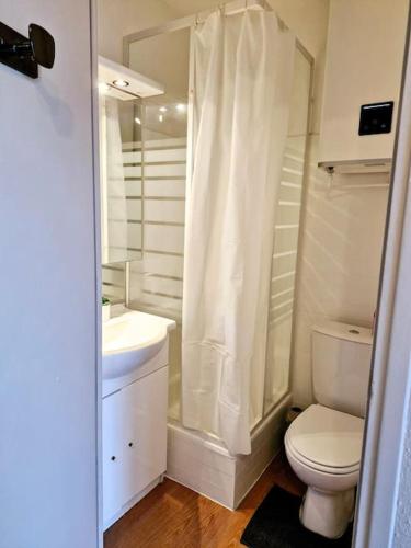 une salle de bain blanche avec des toilettes et un lavabo dans l'établissement Studio cabine pour 4 équipé proche port Cap d'Agde, au Cap d'Agde